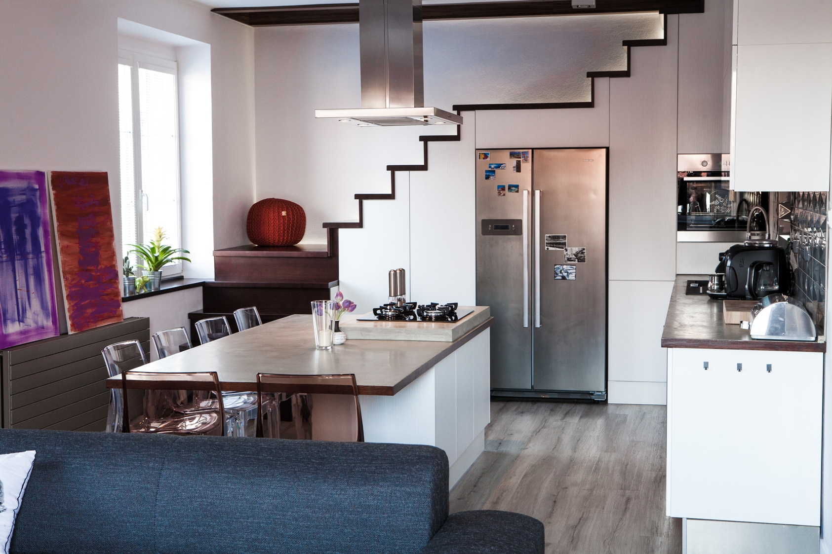 Barbora Sacher: Kuchyň pod schody, Velký stůl uprostřed umožňuje obcházení z obou stran